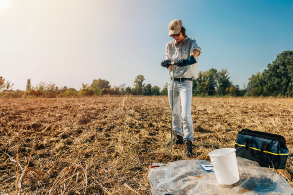Environmental engineer in a field performing a test to assess the quality of the soil and water